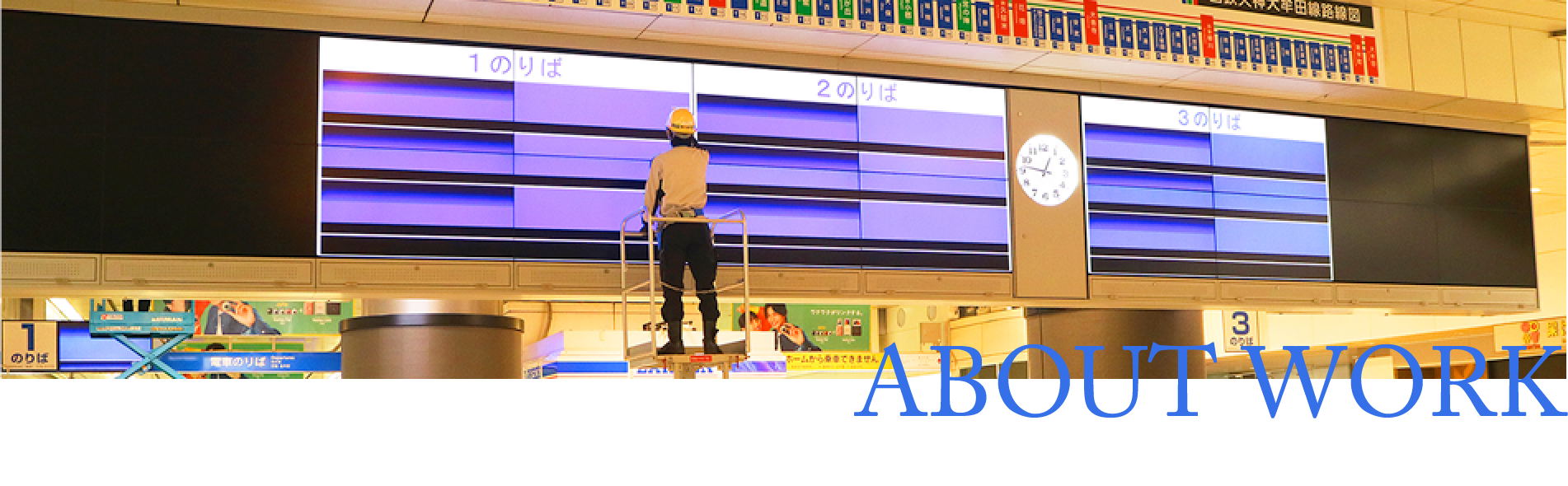 福岡駅北口コンコースの案内装置を点検する技術員